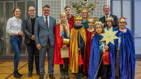 Eine Gruppe Sternsinger mit Staatsminister Wintermeyer und Ministerpräsident Rhein in der Staatskanzlei