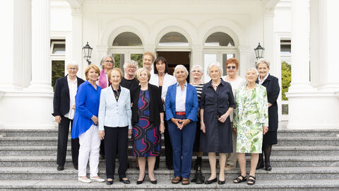 Bild zeigt mehrere Frauen vor Gebäude