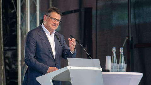 Ministerpräsident Boris Rhein steht an einem Rednerpult auf einer Bühne in der BRITA-Arena in Wiesbaden und redet zu den Teilnehmerinnen und Teilnehmern der Freisprechungsfeier der Kreishandwerkerschaft Wiesbaden-Rheingau-Taunus.