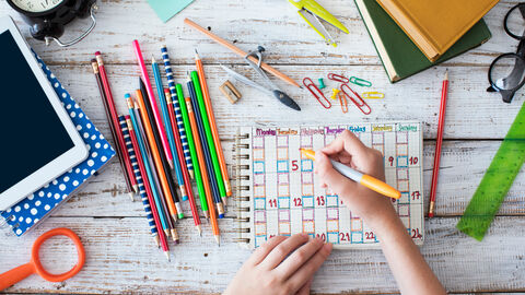 Jemald malt einen bunten Stundenplan, drumherum liegen viele Stifte