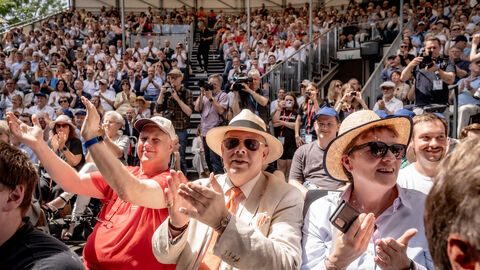 EInen große Menschenmenge. Die Personen sitzen und klatschen.