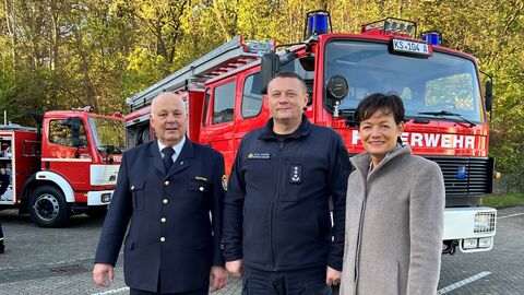 Gruppenfoto vor zwei Feuerwehrfahrzeugen