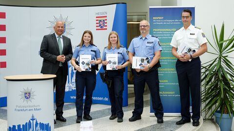 Innenminister Poseck steht mit Polizeibeamten und dem Polizeipräsidenten bei der Vorstellung der neuen Dienstausweise zusammen.