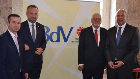 Innenminister Roman Poseck steht mit drei weiteren Männern vor einem Plakat mit der Aufschrift BdV - Bund der Vertriebenen.
