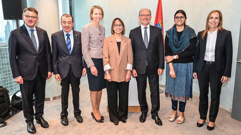 Ministerpräsident Rhein steht mit mehreren Personen des Consular Corps zusammen.